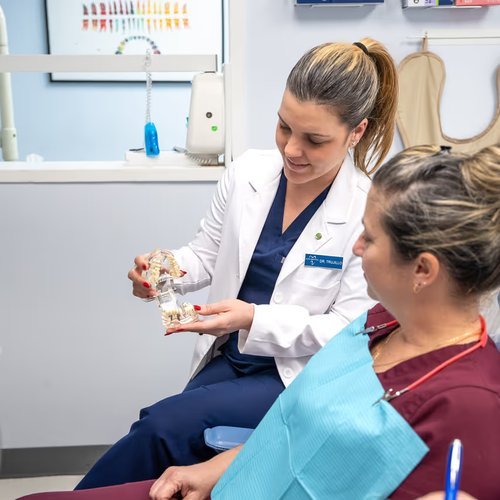 Dentist showing a denture model to a patient