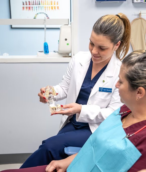 Dentist showing a denture model to a patient