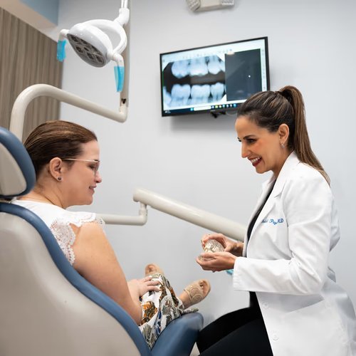 Dentist talking with a patient in the treatment chair